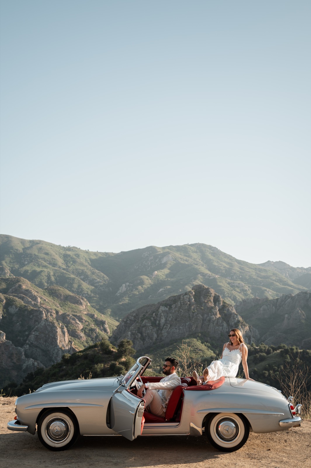Side profile of the silver 190 SL on a Malibu canyon overlook with a couple in the car