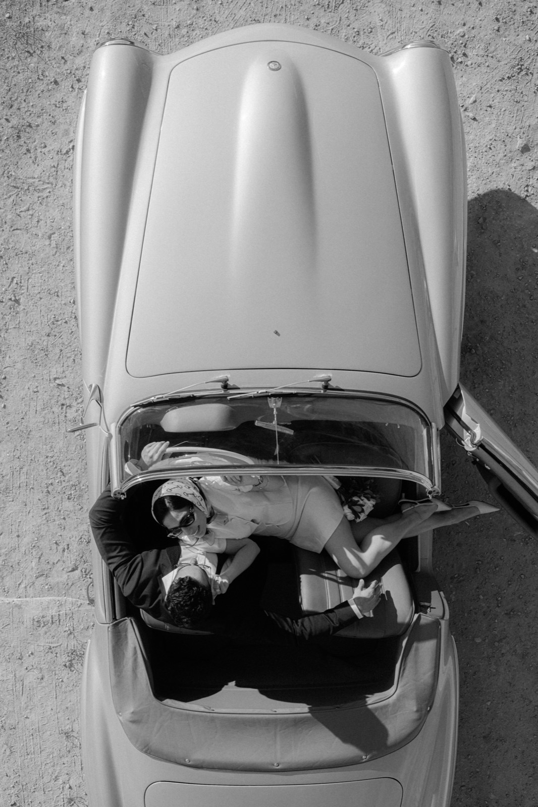 Aerial black and white photograph of a couple in the open-top 190 SL