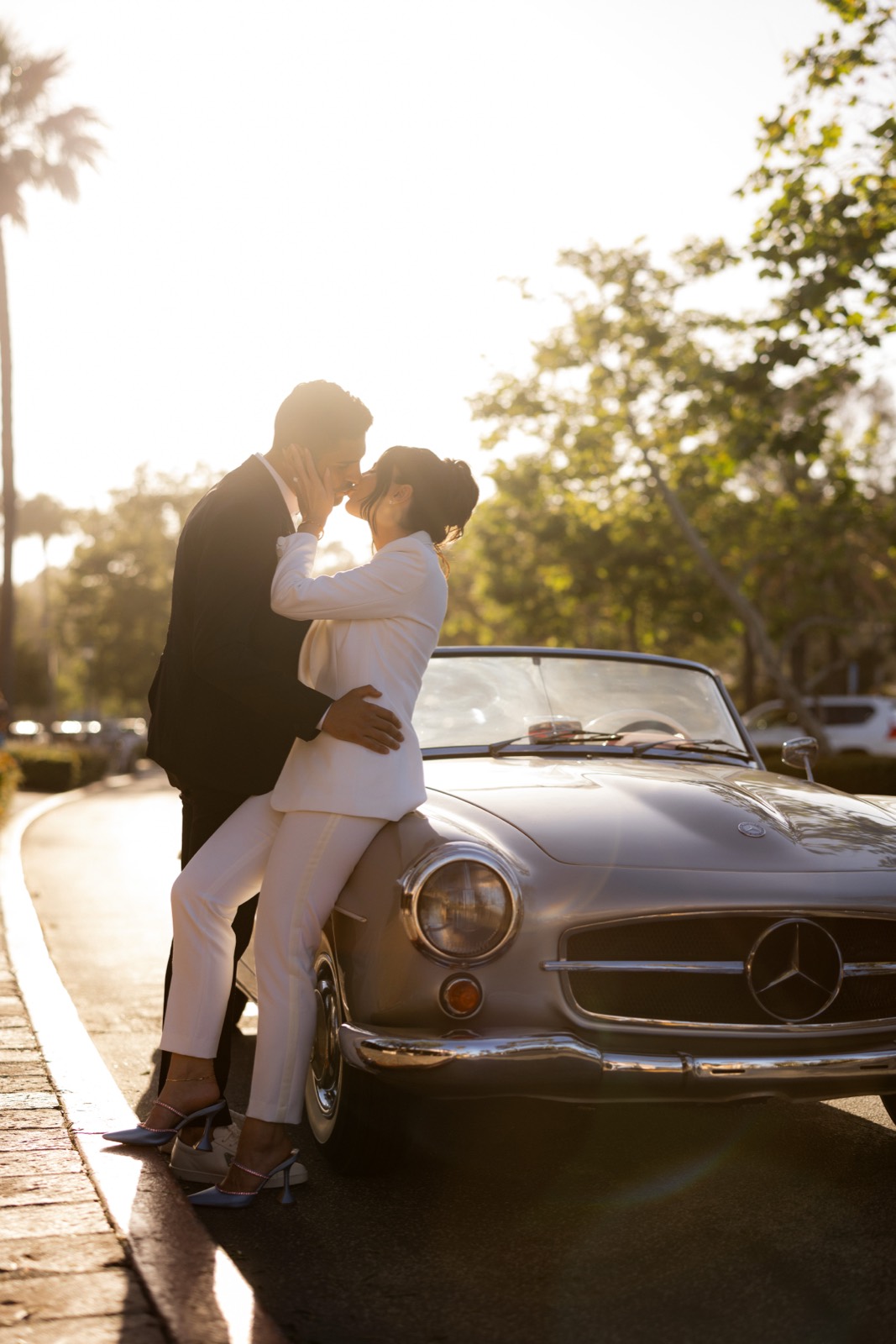 Couple kissing beside the 190 SL grille at sunset in Malibu