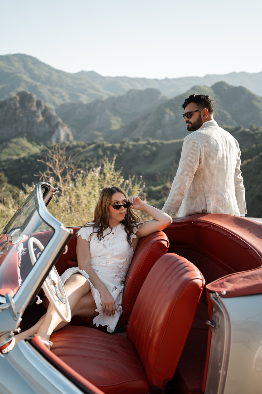 Editorial portrait of a couple with the 190 SL red leather interior in the Malibu mountains